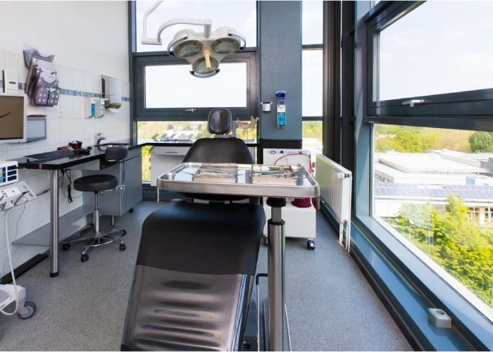 Eine Zahnarztpraxis mit großem Fenster und einem Zahnarztstuhl