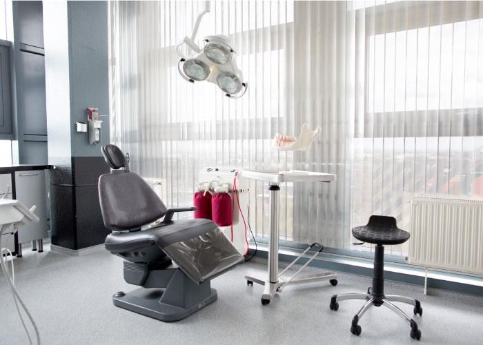 Eine Zahnarztpraxis mit einem Zahnarztstuhl und einem Hocker