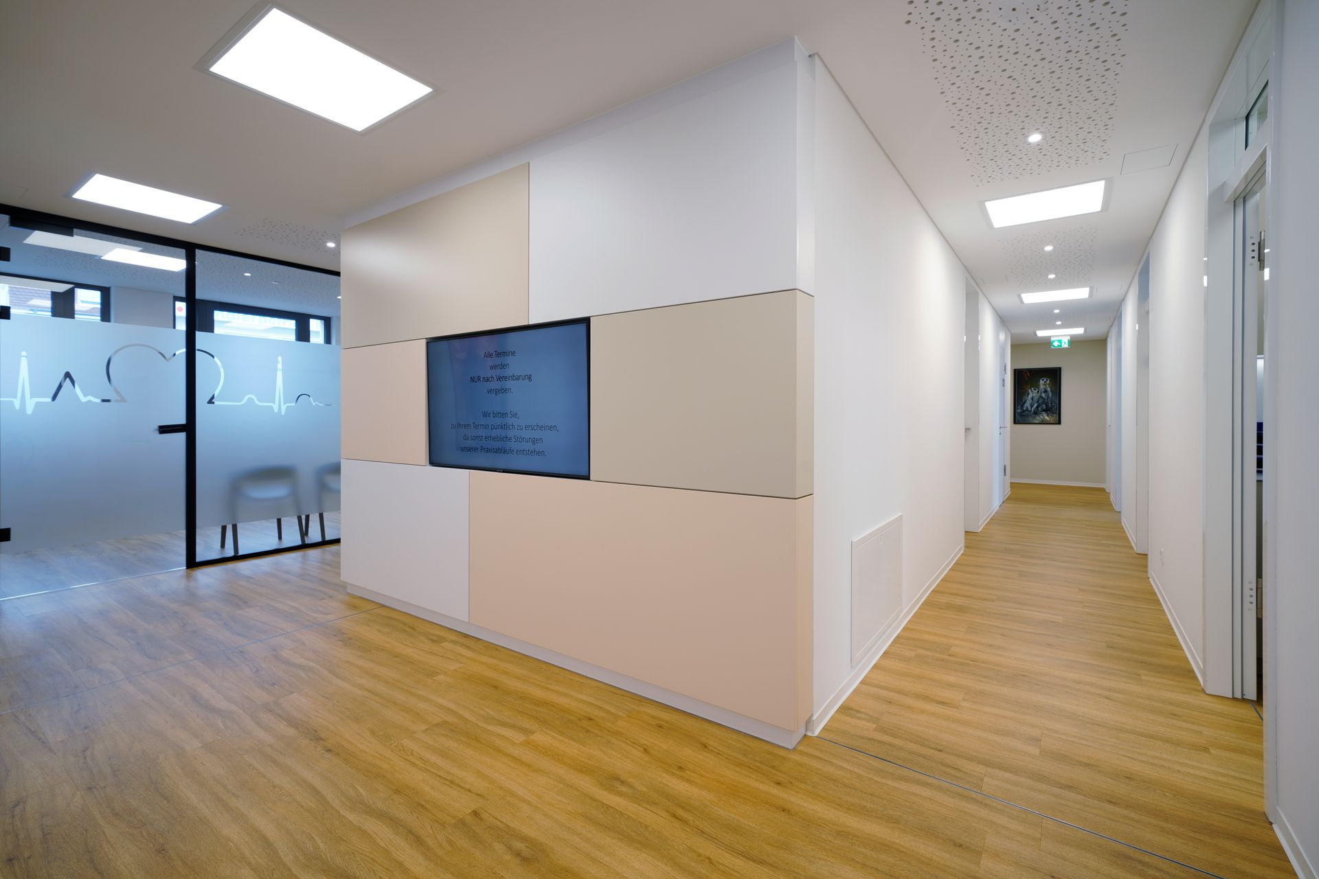 Ein langer Flur mit einem Flachbildfernseher an der Wand.