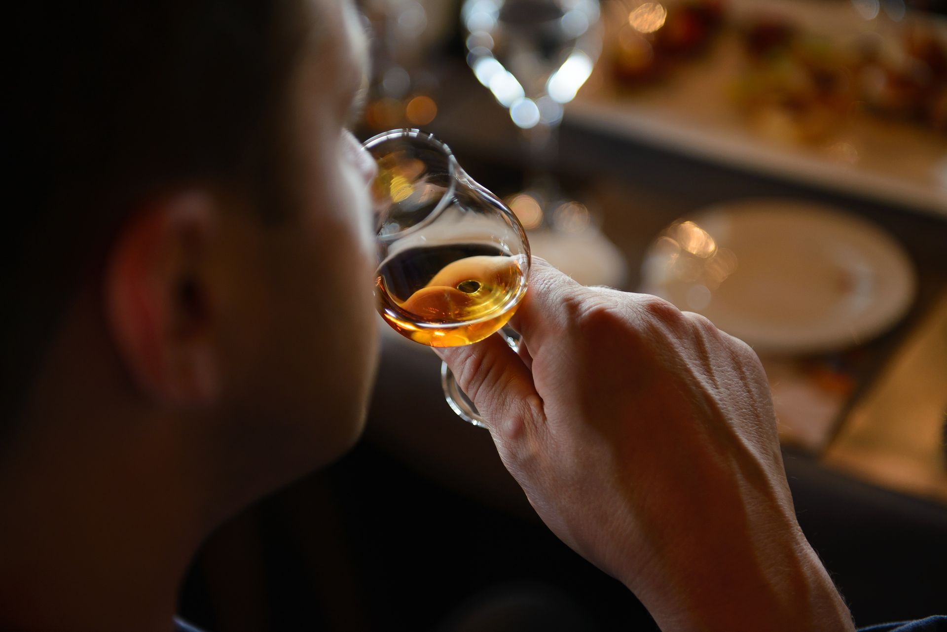 Un homme boit un digestif dans un restaurant.