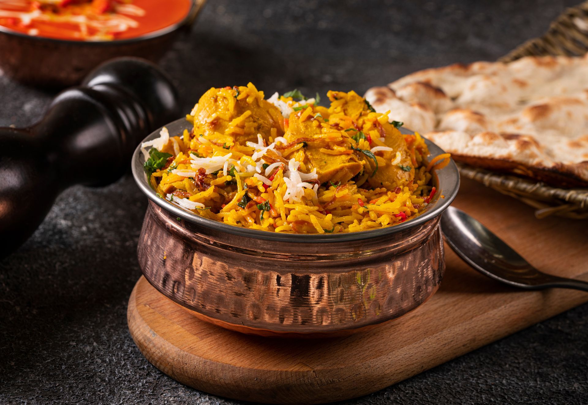 Un biryani au poulet, servi avec un naan.