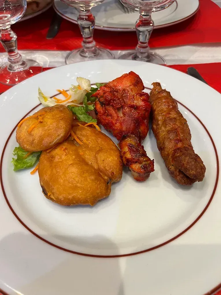 Plusieurs viandes dans une assiette : poulet et saucisse.