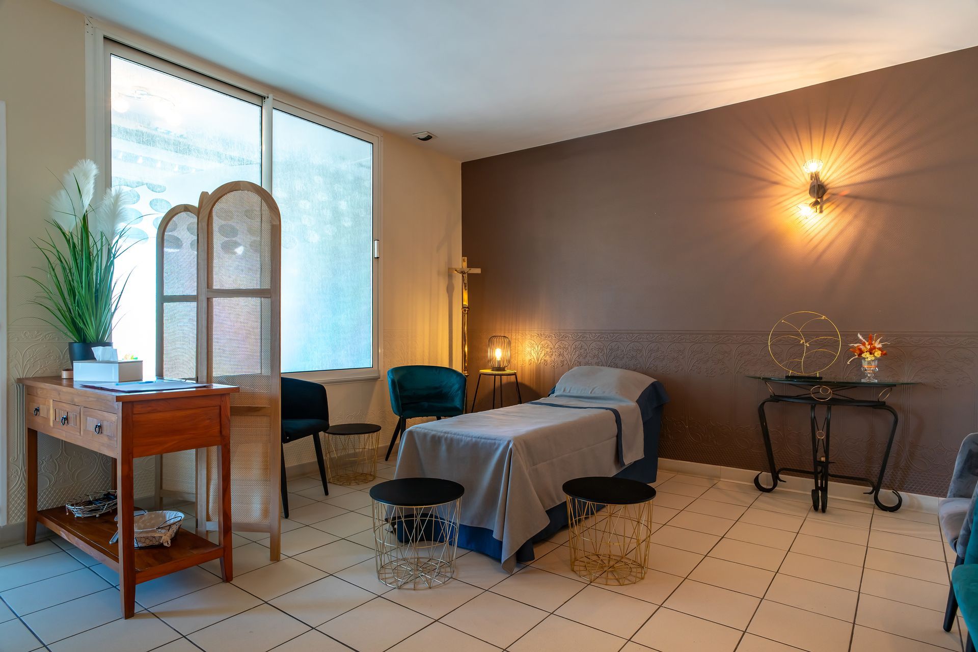 Chambre funéraire, chaises en velours, bureau antique, mur d'accent marron, lumière naturelle et éléments décoratifs.