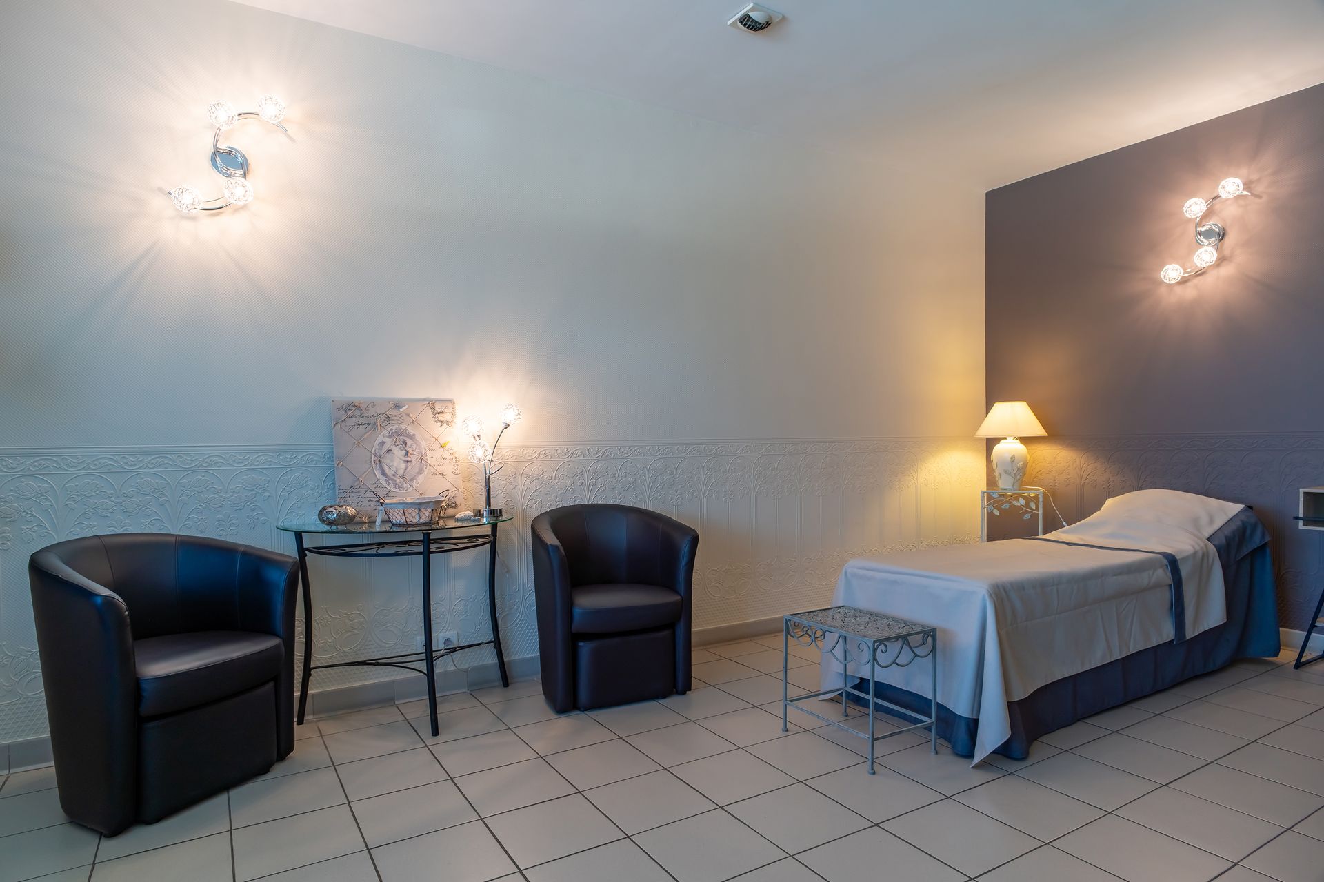 Chambre funéraire avec un lit, des chaises, des tables de chevet et des murs aux tons neutres.