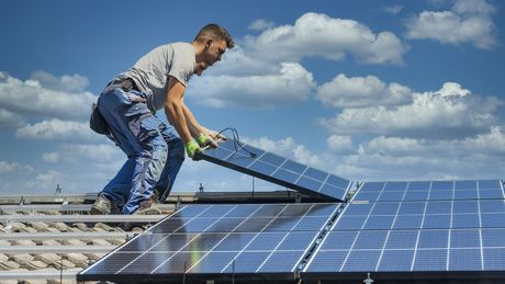 Photo d'un homme installant des panneaux solaires