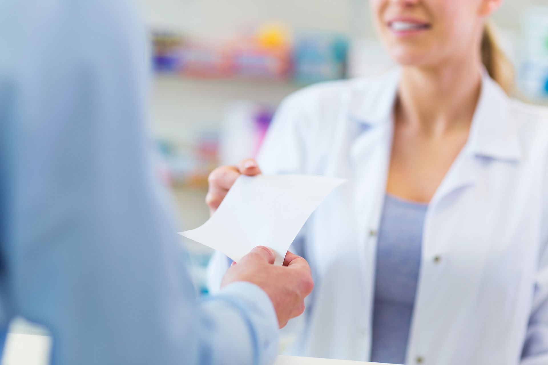Une personne donnant son ordonnance à une pharmacienne.