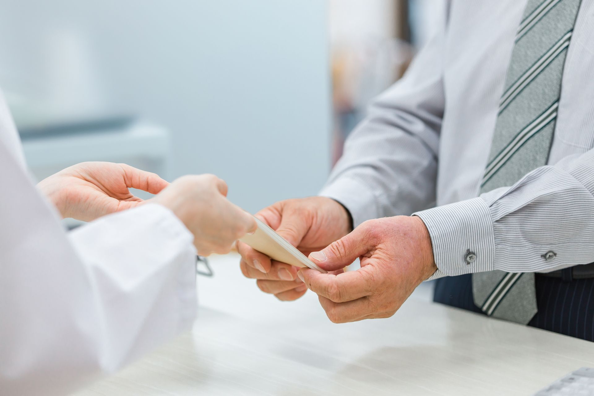 Une personne tendant son ordonnance à un pharmacien.