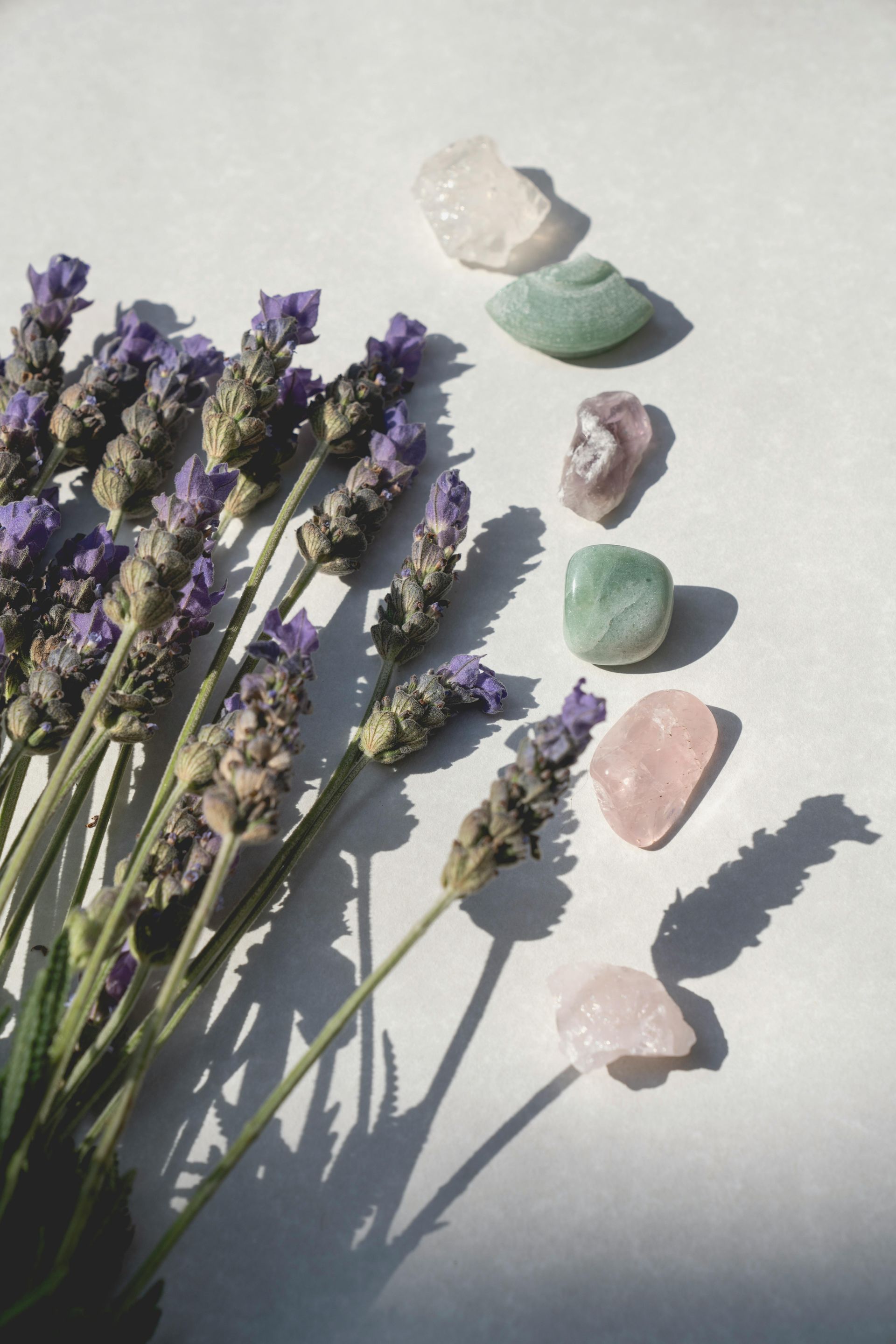 Ein Strauß lila Blumen und Kristalle auf einer weißen Oberfläche.