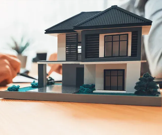 Una casa modelo está sentada sobre una mesa de madera.