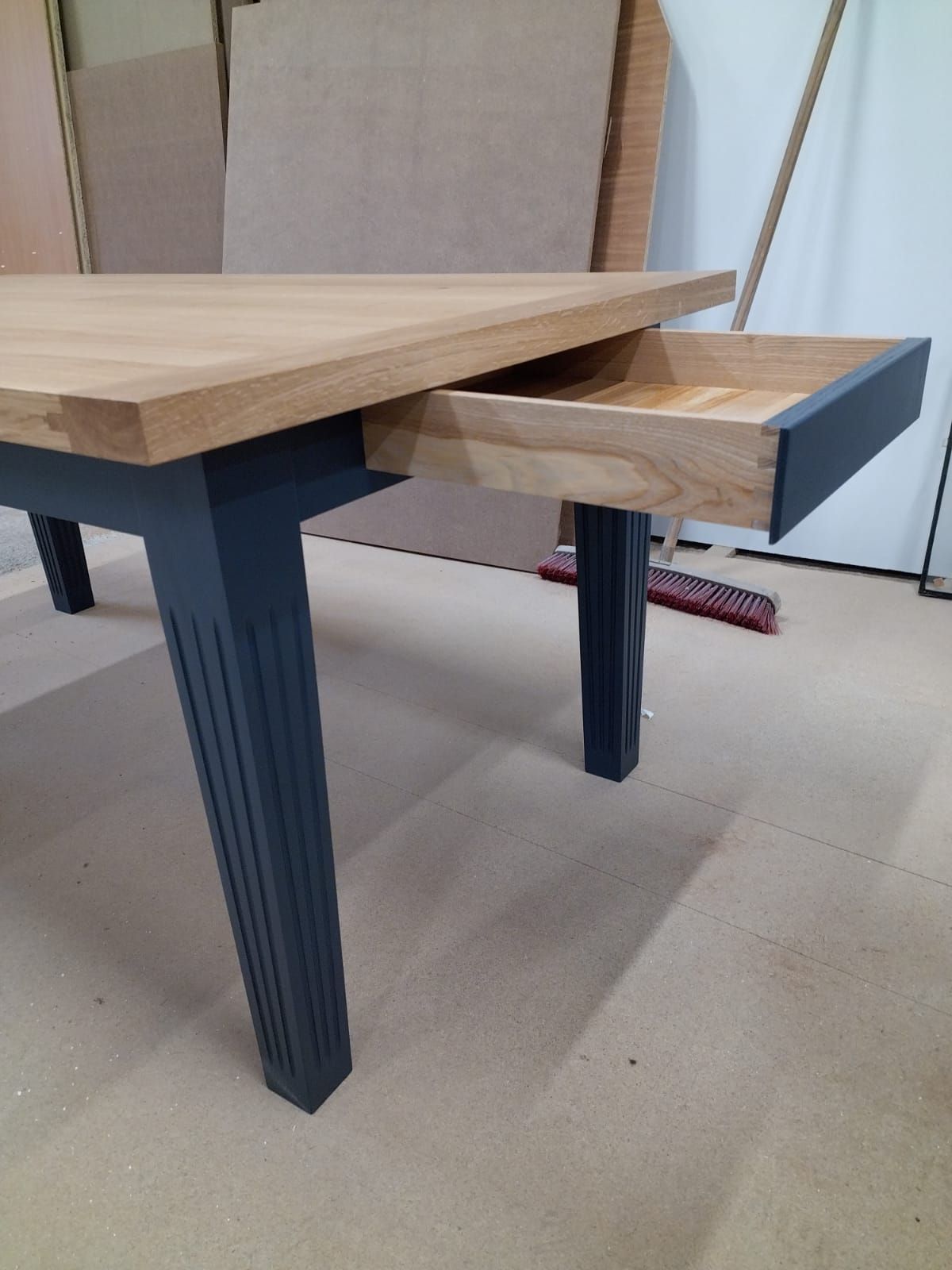 Table en bois avec pieds noirs et tiroir ouvert