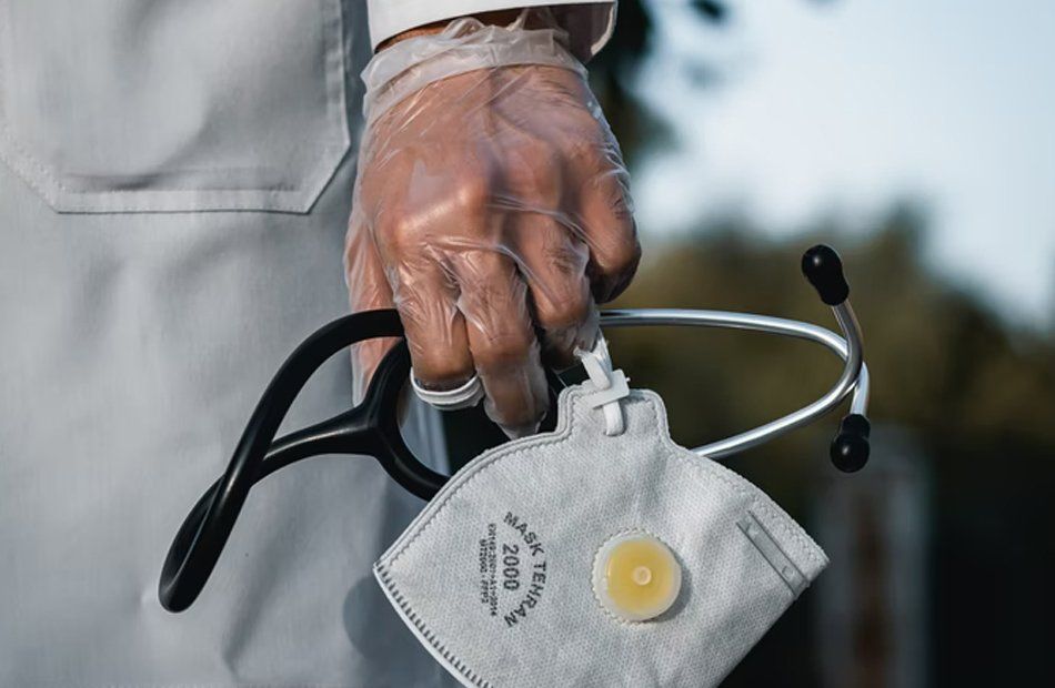 Un homme tenant un masque médical dans sa main