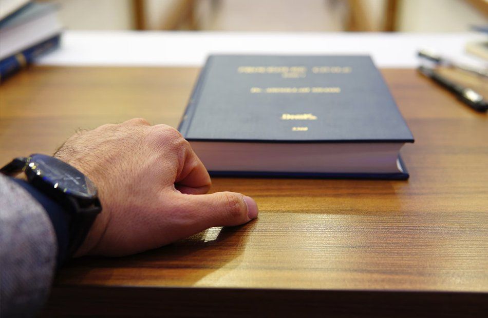 Une main tendue vers un livre sur un bureau