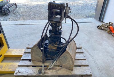 Auf einer Holzpalette steht eine Hydraulikschaufel.