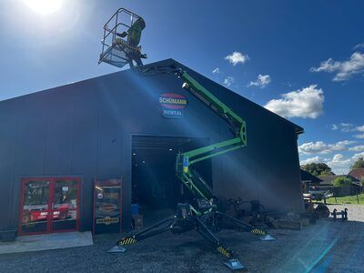 Ein Mann steht auf einem Aufzug vor einem Gebäude.