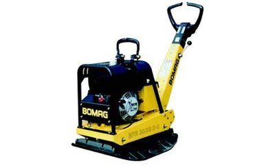 Auf einer weißen Fläche steht ein gelb-schwarzer Bomag-Kompaktor.