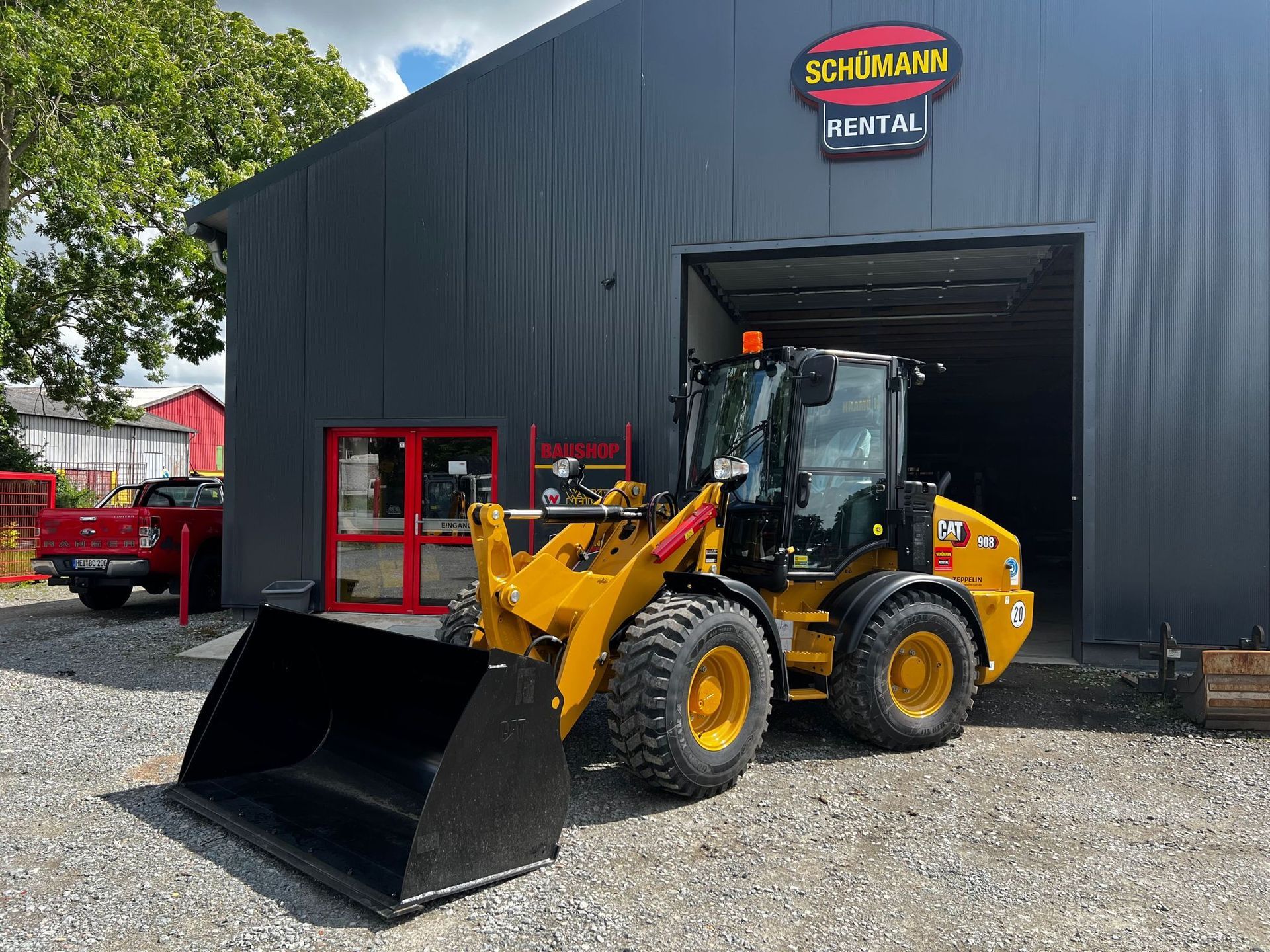 Vor einem Gebäude steht eine Planierraupe.