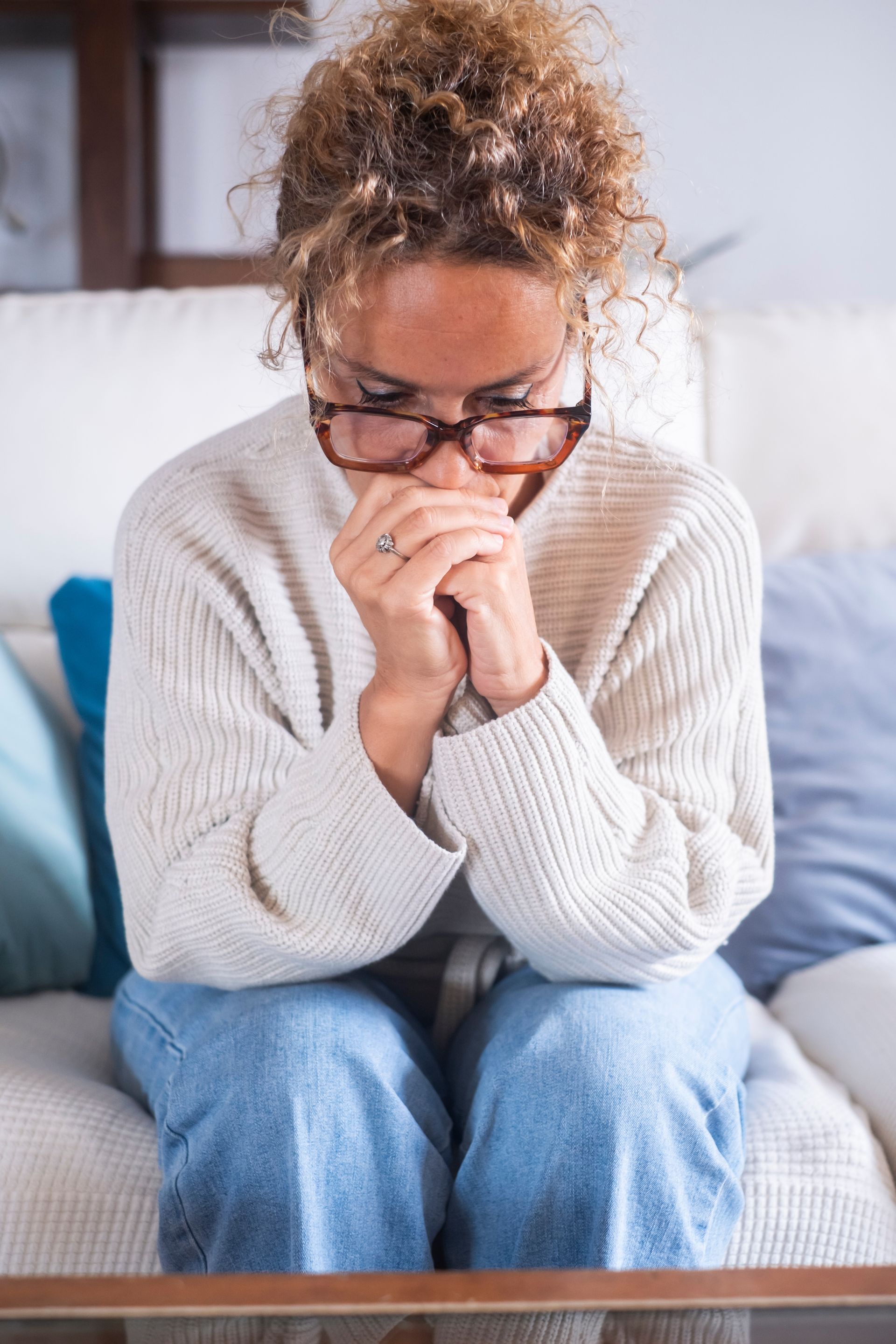 Une femme contrariée assise sur un canapé.