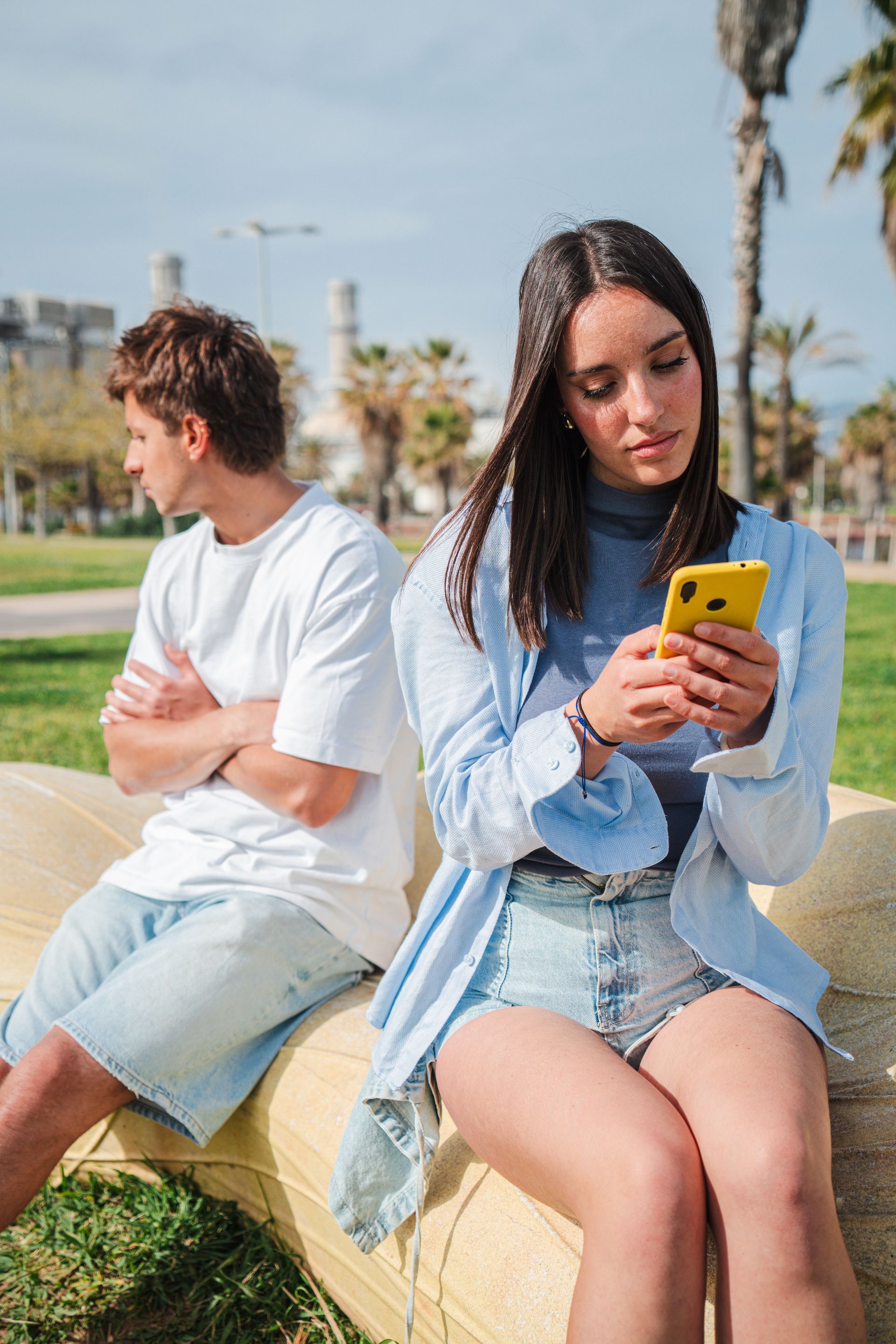 Deux adolescents contrariés dont une sur un téléphone.