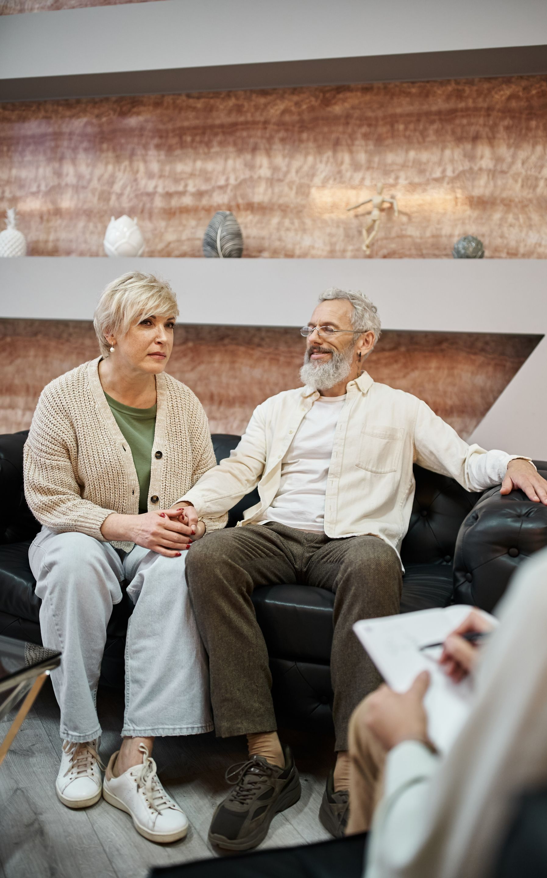Couple sur un canapé noir en consultation conjugale.