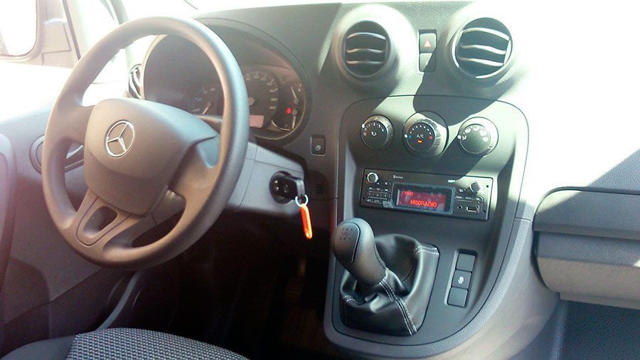 El interior de un coche con volante y radio.