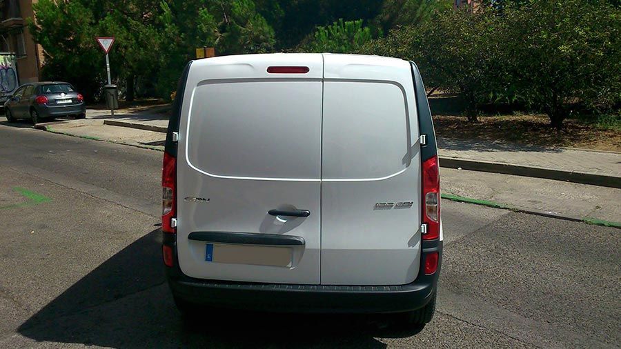 Una camioneta blanca está estacionada al costado de la carretera.