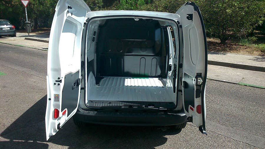 La parte trasera de una furgoneta blanca con las puertas abiertas.