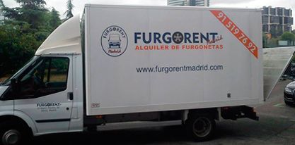 Un camión furgonet blanco está estacionado en un estacionamiento