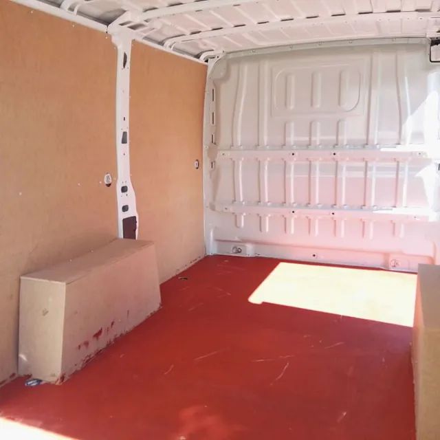 El interior de una furgoneta vacía con suelo rojo.