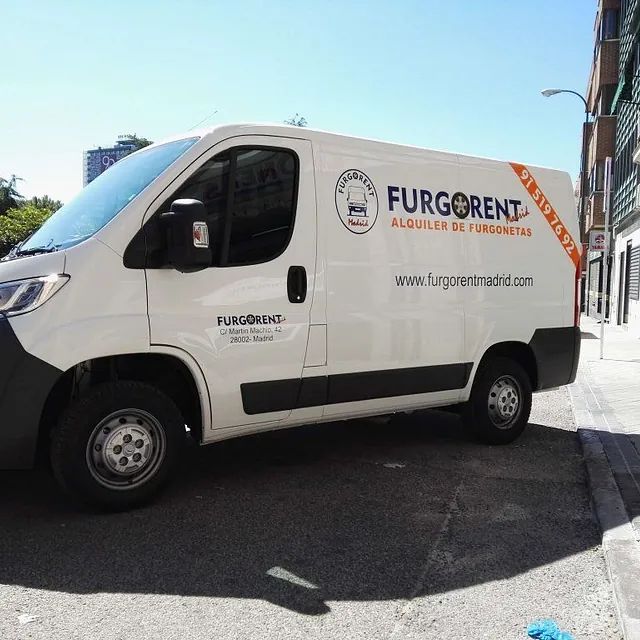 Una furgoneta blanca está estacionada al costado de la carretera.