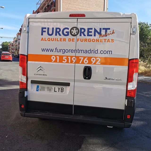 Una furgoneta blanca de Furgorent está estacionada al costado de la carretera.