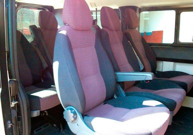 El interior de una furgoneta con asientos morados y negros.