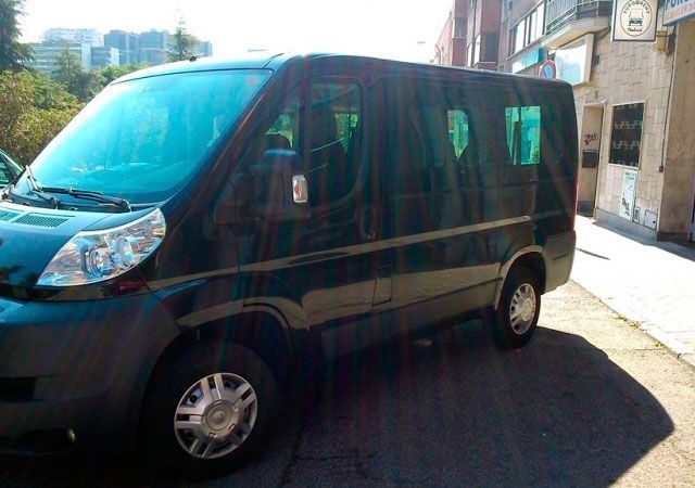 Una camioneta negra está estacionada al costado de la carretera frente a un edificio.