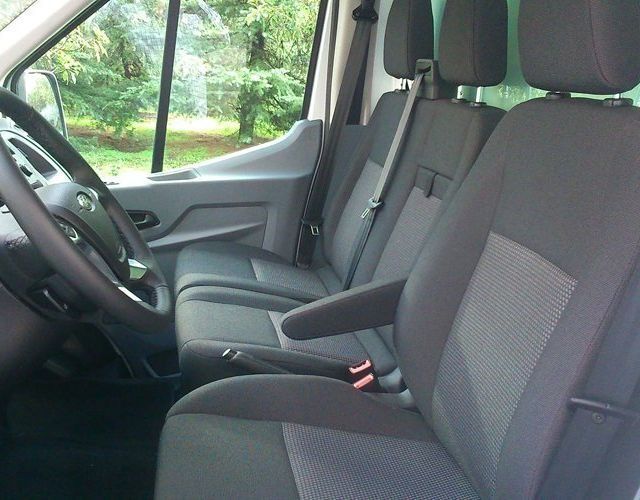 El interior de una furgoneta con volante y asientos.