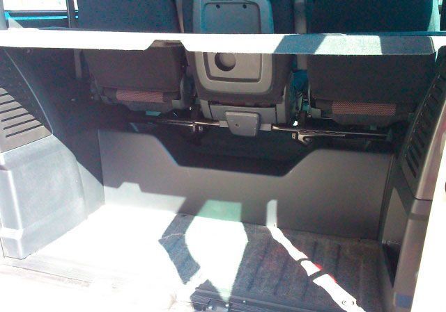 El asiento trasero de un coche tiene un estante encima.