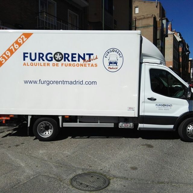 Una furgoneta blanca está estacionada al costado de la carretera