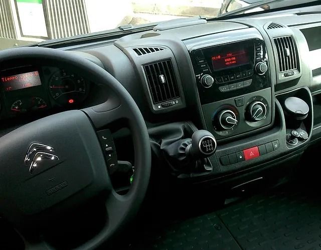 El interior de un coche con volante y radio.