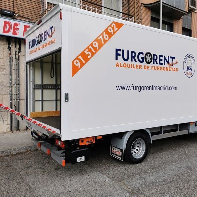 Un camión furgoneta blanco está estacionado al costado de la carretera.