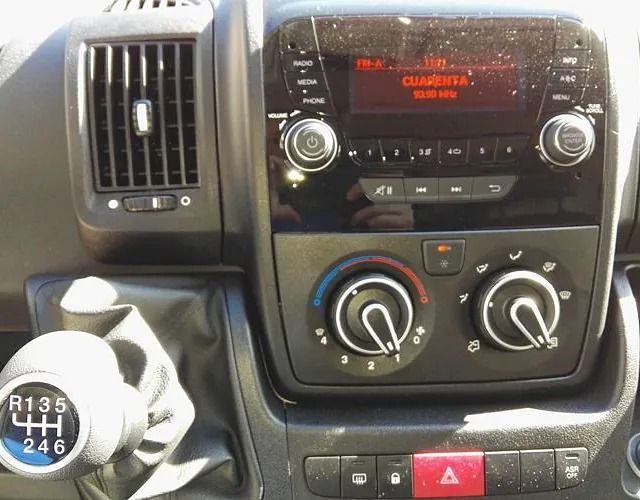 Un primer plano del tablero de un automóvil con radio y control de climatización.