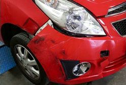 Rote Wagenfront vor der Unfallreparatur mit Schaden