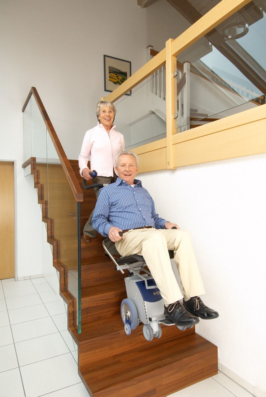 Un hombre en silla de ruedas es empujado por una mujer por las escaleras.