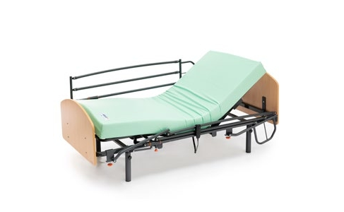 Una cama de hospital con un colchón verde y un marco de madera sobre un fondo blanco.