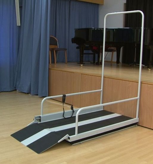 Una rampa está sentada en el suelo frente a un piano.