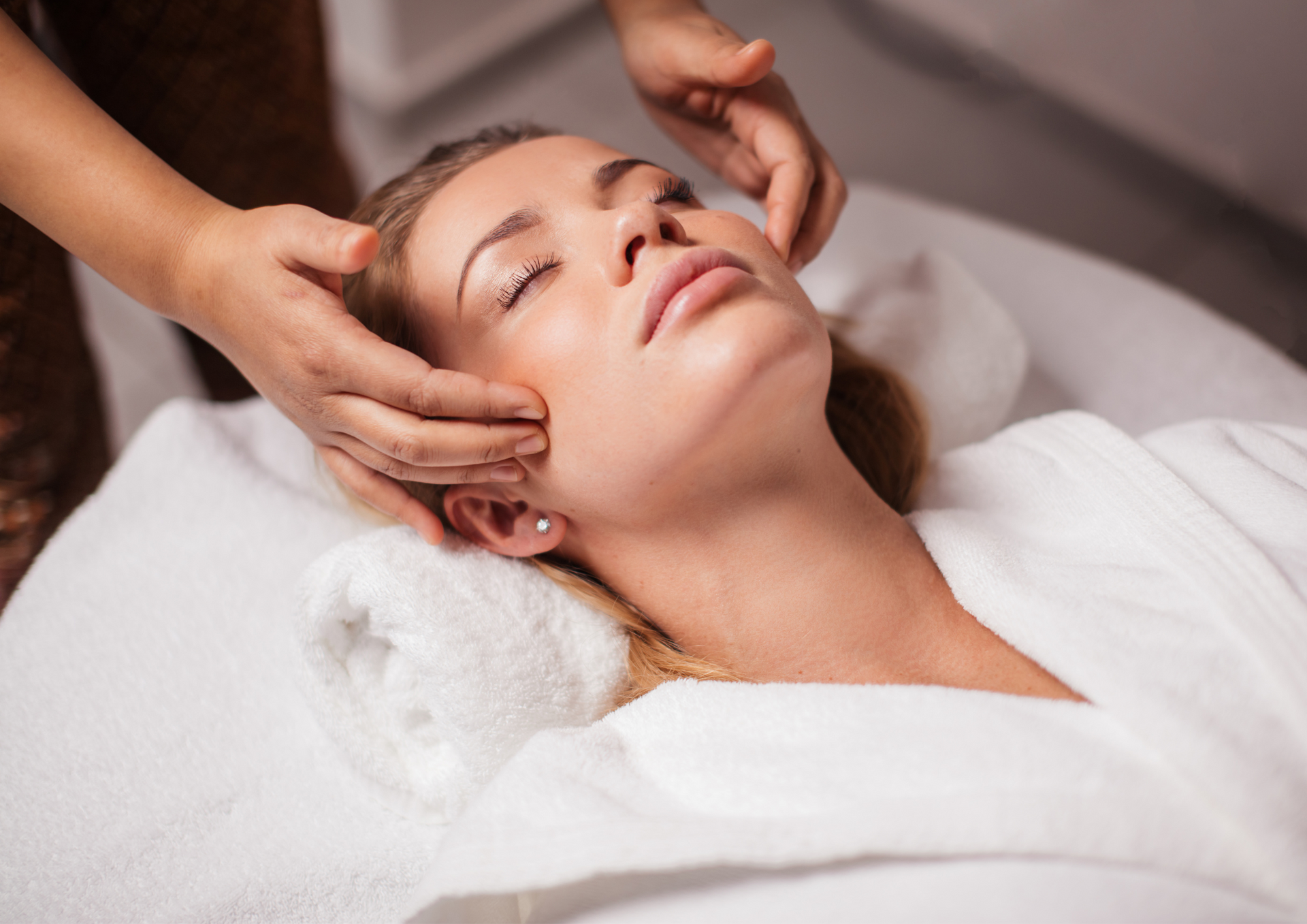 Una mujer está recibiendo un masaje facial en un spa.