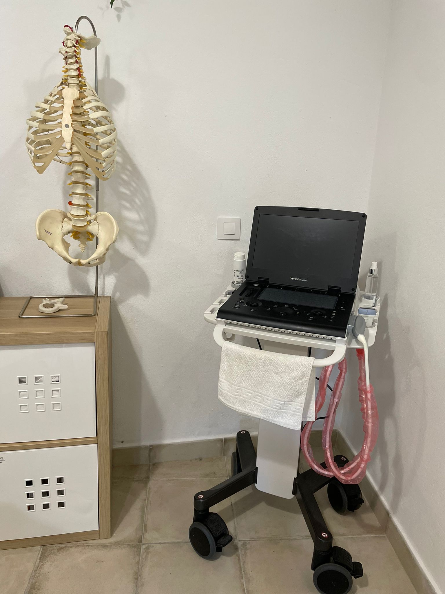 Una computadora portátil HP está en un carrito junto a una cama.