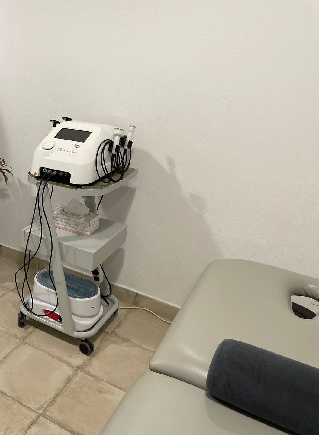 Una habitación con una mesa de masajes y un cuadro en la pared.