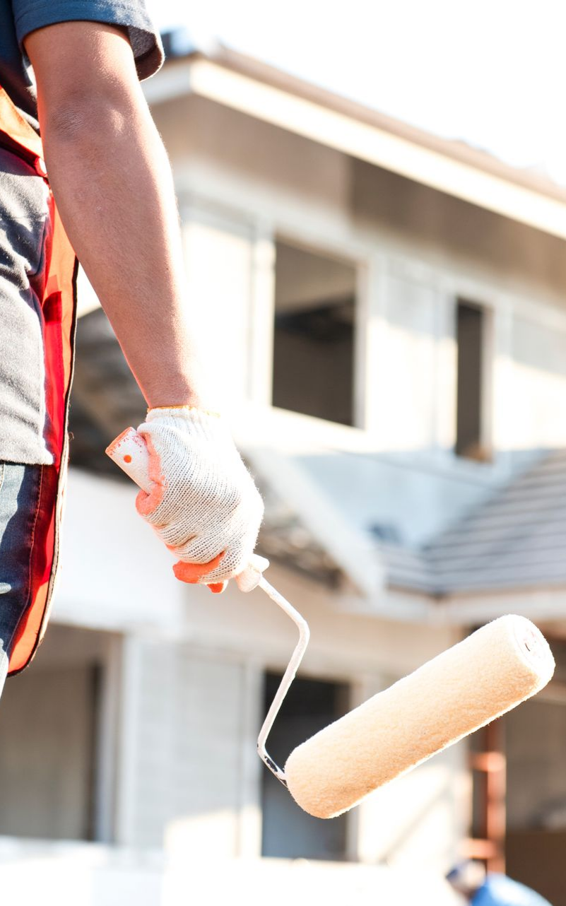 Un peintre avec un rouleau à la main.
