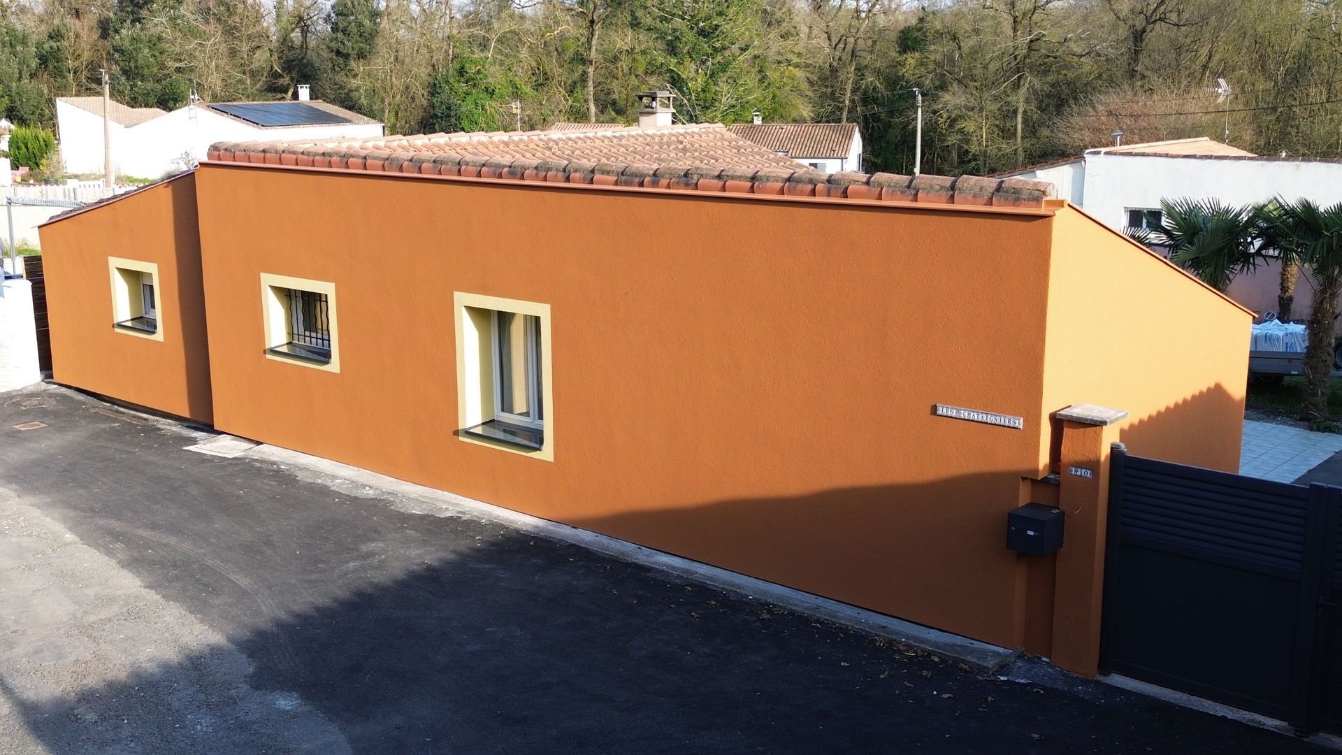 Une maison avec un revêtement extérieur gris clair.