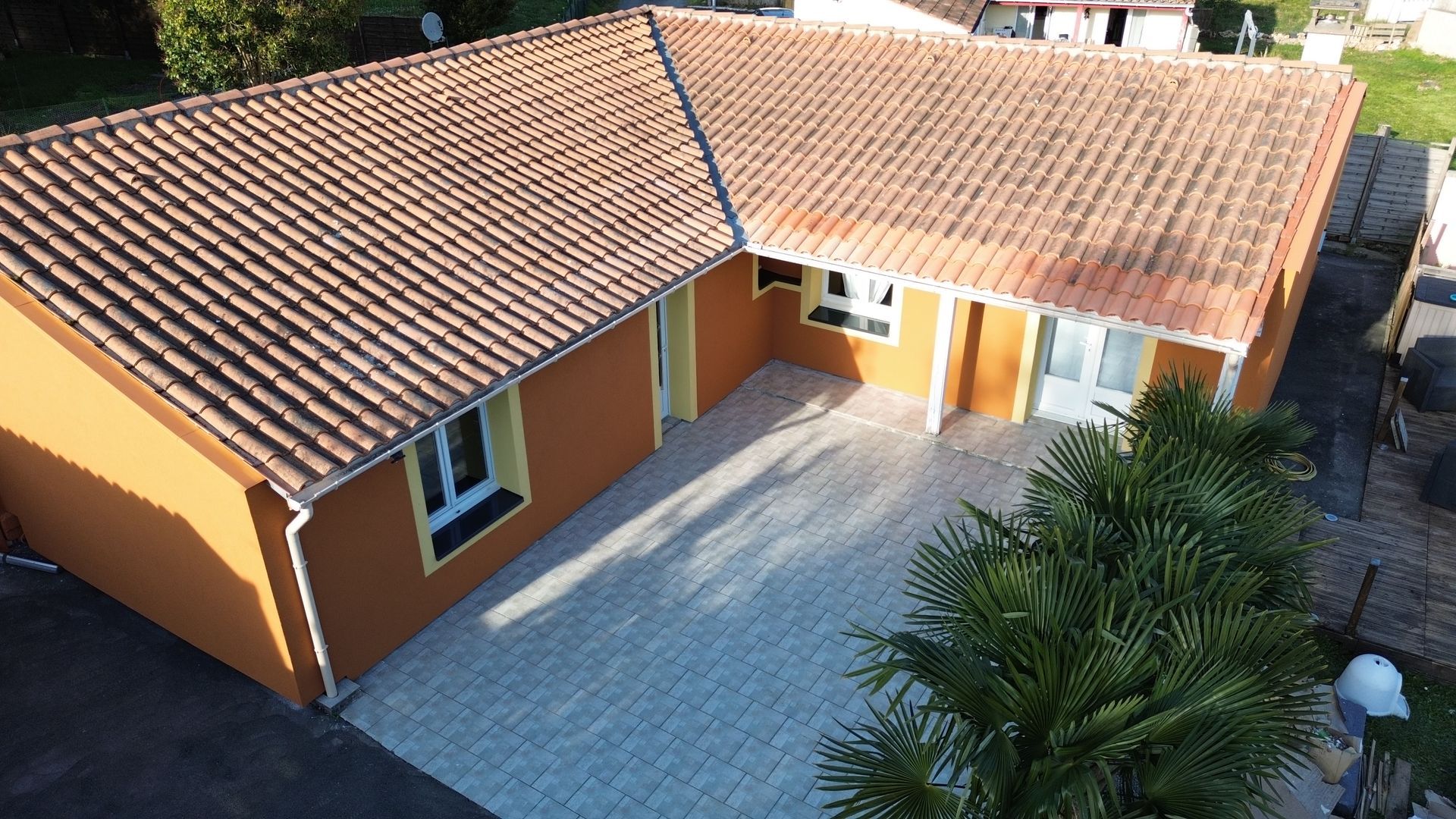 Une maison rose avec un jardin.