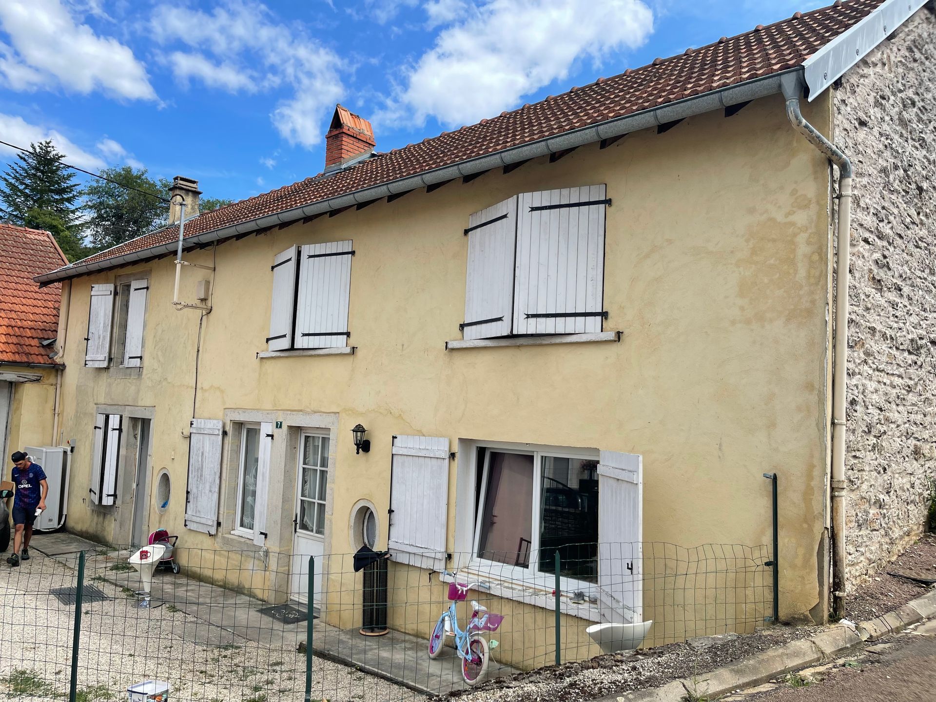 Une maison avec un revêtement extérieur jaune clair.