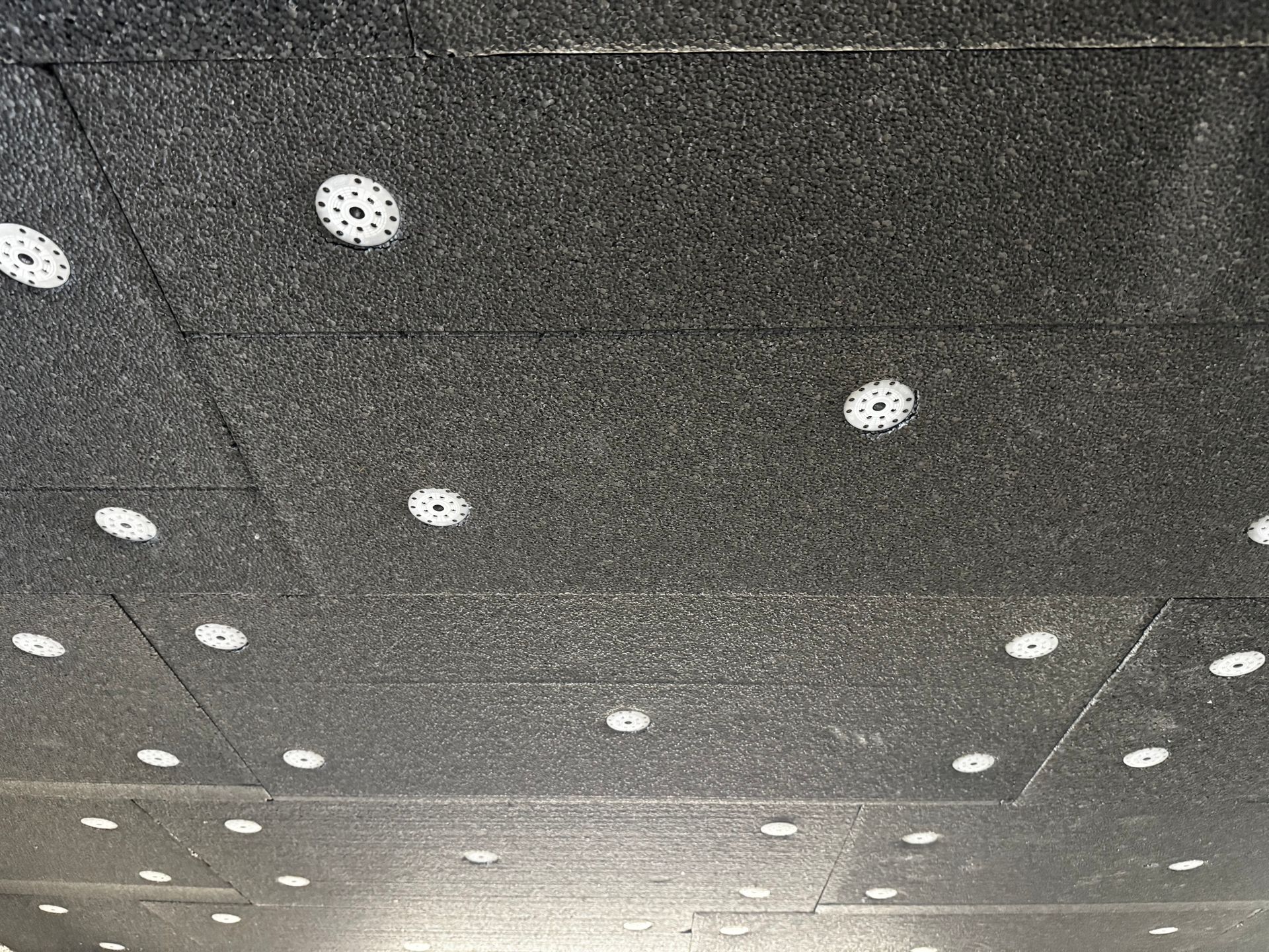 Un plafond avec des dalles noires.